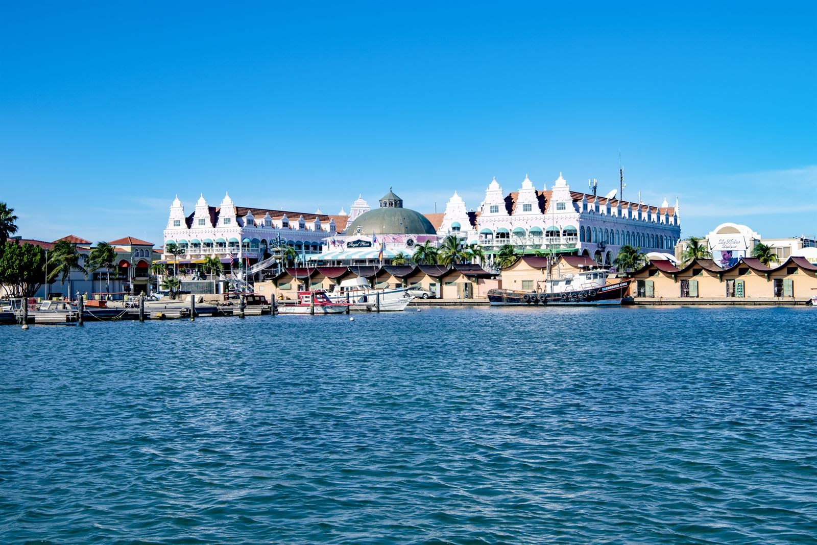 Pastel gabled shopping arcade and moored boats along the Oranjestad waterfront, Aruba