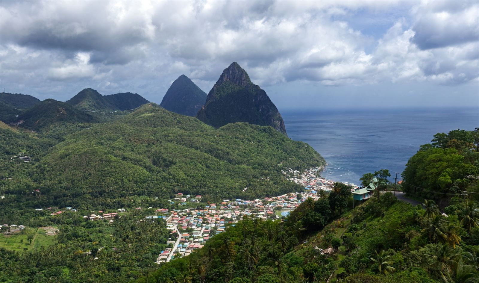 The twin Pitons rising above the town of Soufriere and green hills on St. Lucia